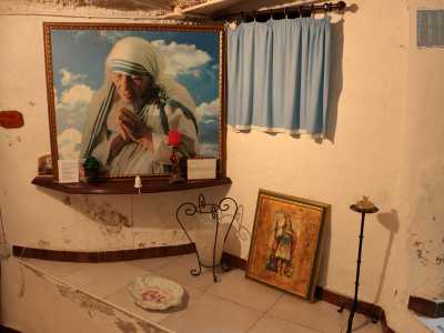 Sulla parete destra un�imponente cornice inquadra la foto di Madre Teresa di Calcutta nell�atto di pregare, immersa tra le nuvole bianche e il cielo azzurro